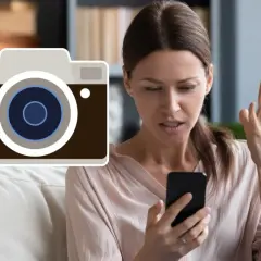 Zirytowana kobieta patrzy na telefon, obok ikona aparatu z wykrzyknikiem. Zastanawia się, dlaczego nie mogę zrobić zdjęcia telefonem.