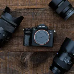 Sony Alpha 7 III z trzema obiektywami. Wybór między lustrzanką czy bezlusterkowcem to kluczowa decyzja fotografa.