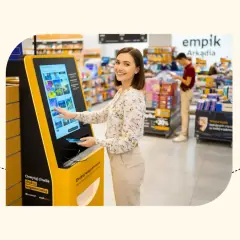 Kobieta korzysta z kiosku Empik, by wydrukować zdjęcia. Tak, w Empiku można wywołać zdjęcia od ręki, tworząc natychmiastowe wspomnienia.
