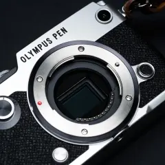 Zbliżenie na matrycę aparatu Olympus PEN z widocznym bagnetem obiektywu.