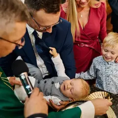 Chrzest dziecka w kościele, rodzice i ksiądz.