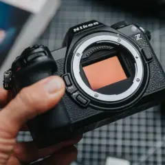Dłoń trzyma aparat Nikon Z z widocznym sensorem.