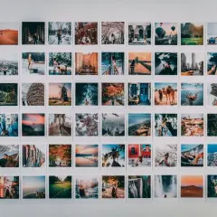 Inspiracja do tego, jak zrobić kolaż zdjęć na komputerze: ściana ozdobiona mnóstwem małych, podróżniczych fotografii.