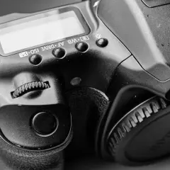 Zbliżenie na lustrzankę Canon 1000D, widoczne przyciski sterujące i pokrętło.
