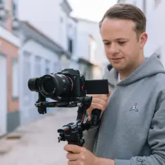 Mężczyzna trzyma profesjonalny aparat do filmowania Sony Alpha 7 na stabilizatorze Ronin S2.