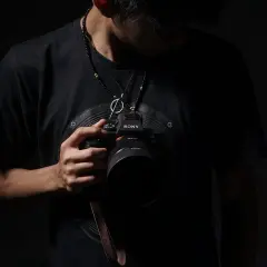 Mężczyzna z aparatem Sony, gotowy do uchwycenia wyjątkowych chwil. Szukasz inspiracji, jak znaleźć fotografa ślubnego?
