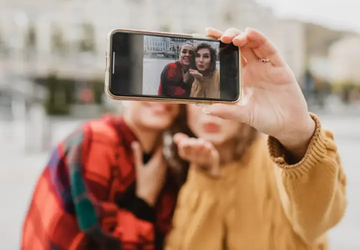 Dwie przyjaciółki robią sobie selfie telefonem. Chcesz wywołać zdjęcia z telefonu? To proste!