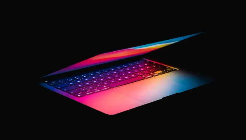 Kolorowy laptop, idealny do pracy w Photoshopie, z podświetlaną klawiaturą w odcieniach tęczy.