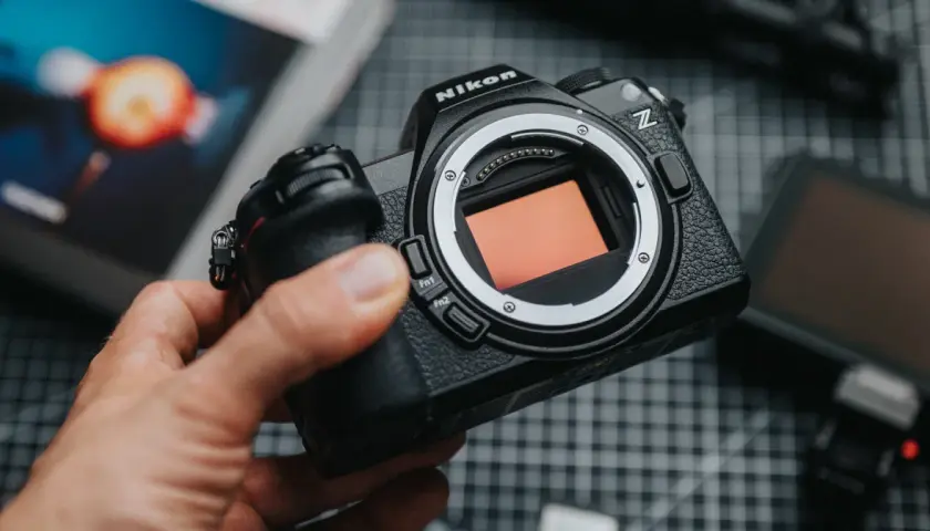 Dłoń trzyma aparat Nikon Z z widocznym sensorem.