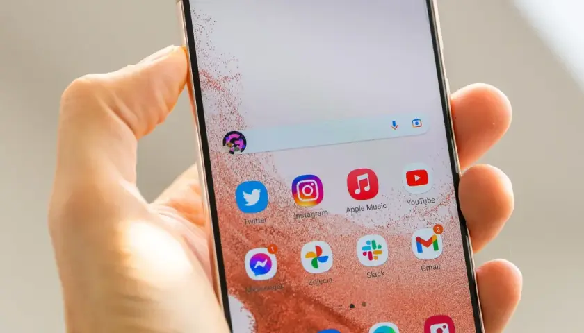 Jak ustawić aparat w Samsung S22? Na ekranie telefonu widać ikony aplikacji: Twitter, Instagram, Apple Music, YouTube, Messenger, Zdjęcia, Slack, Gmail.