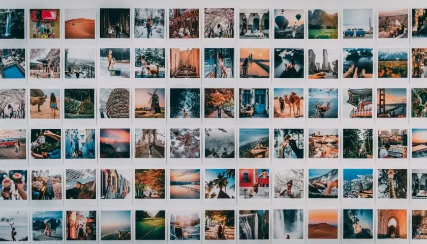 Inspiracja do tego, jak zrobić kolaż zdjęć na komputerze: ściana ozdobiona mnóstwem małych, podróżniczych fotografii.