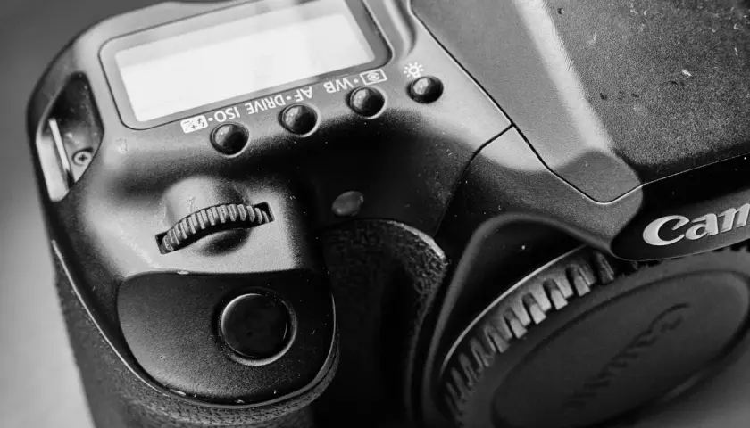 Zbliżenie na lustrzankę Canon 1000D, widoczne przyciski sterujące i pokrętło.
