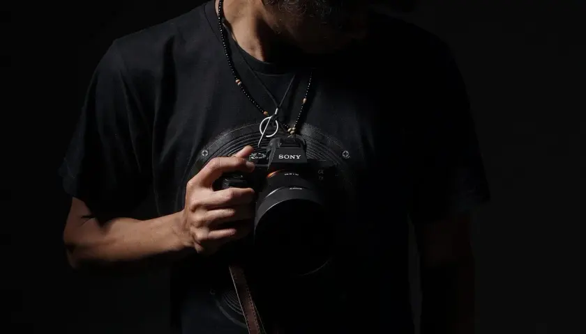 Mężczyzna z aparatem Sony, gotowy do uchwycenia wyjątkowych chwil. Szukasz inspiracji, jak znaleźć fotografa ślubnego?