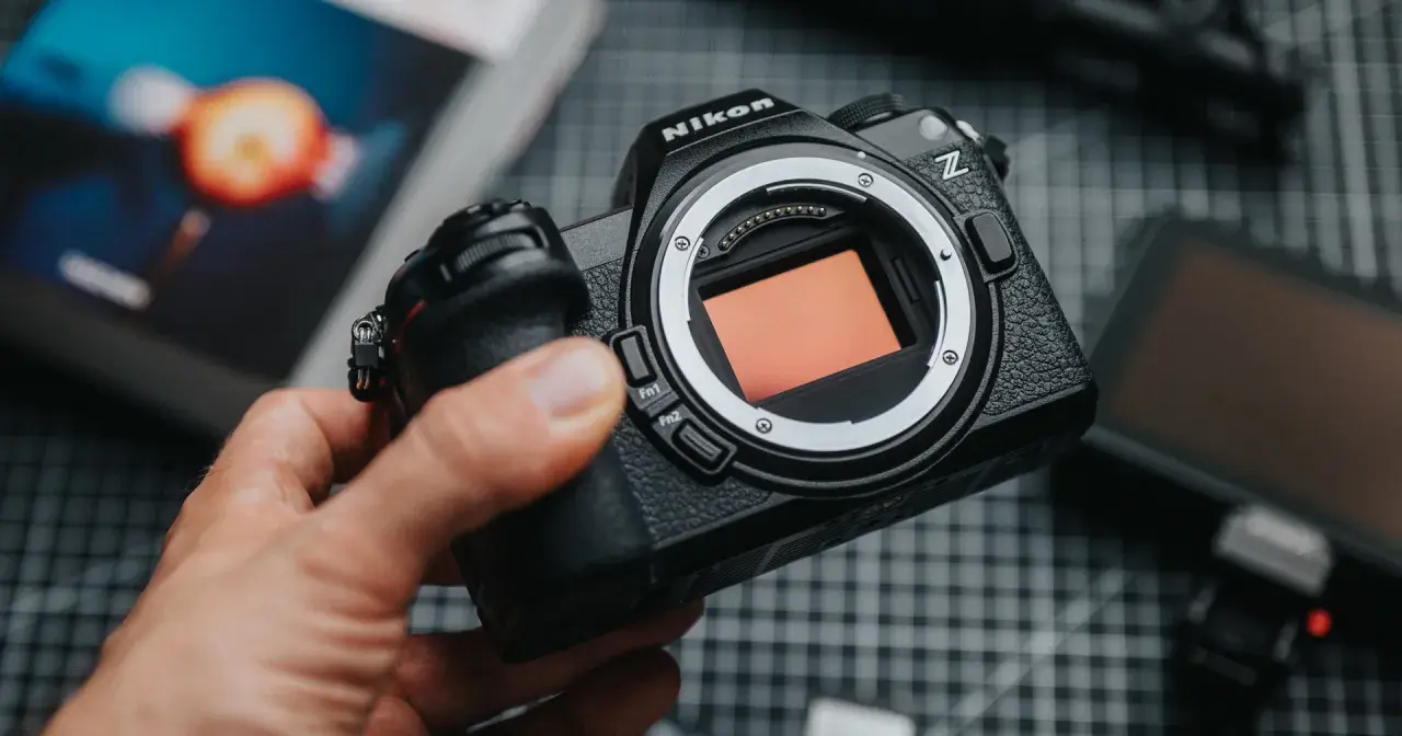 Dłoń trzyma aparat Nikon Z z widocznym sensorem.