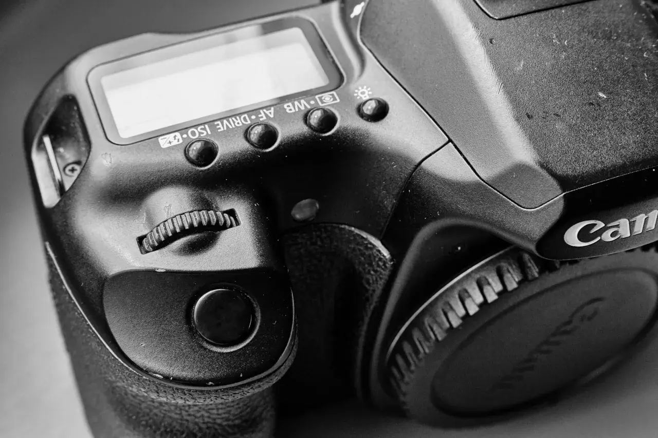 Zbliżenie na lustrzankę Canon 1000D, widoczne przyciski sterujące i pokrętło.