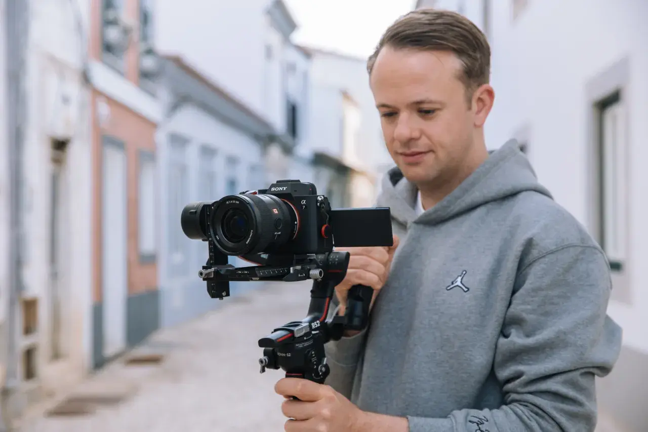 Mężczyzna trzyma profesjonalny aparat do filmowania Sony Alpha 7 na stabilizatorze Ronin S2.