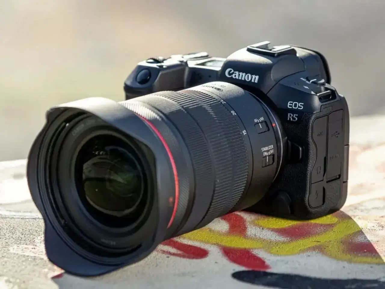 Nowoczesny aparat Canon EOS R5 z obiektywem. Czy taki był jaki pierwszy aparat fotograficzny?