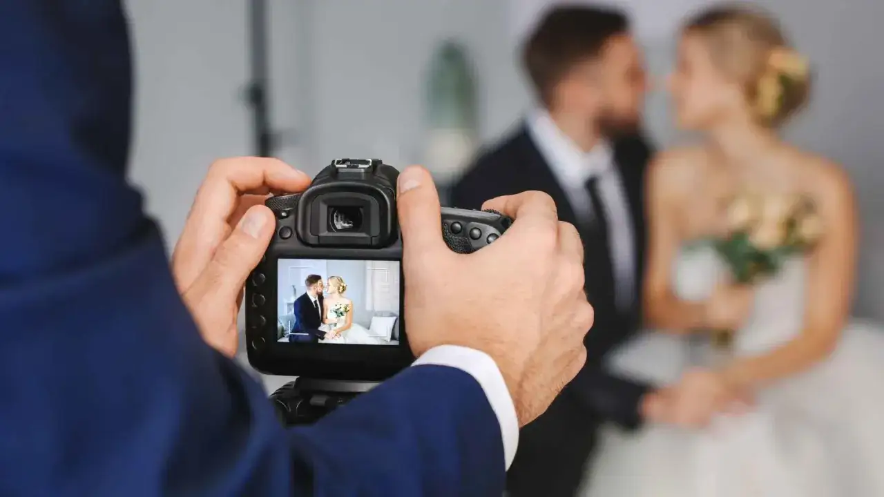 Fotograf robi zdjęcie pary młodej. Zastanawiasz się, co ustalić z fotografem przed ślubem, aby mieć idealne ujęcia?