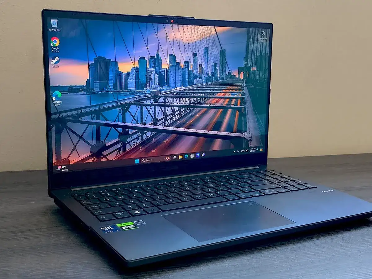 Nowoczesny laptop z podświetlaną klawiaturą, idealny do pracy w Photoshopie. Widok na Brooklyn Bridge na pulpicie.