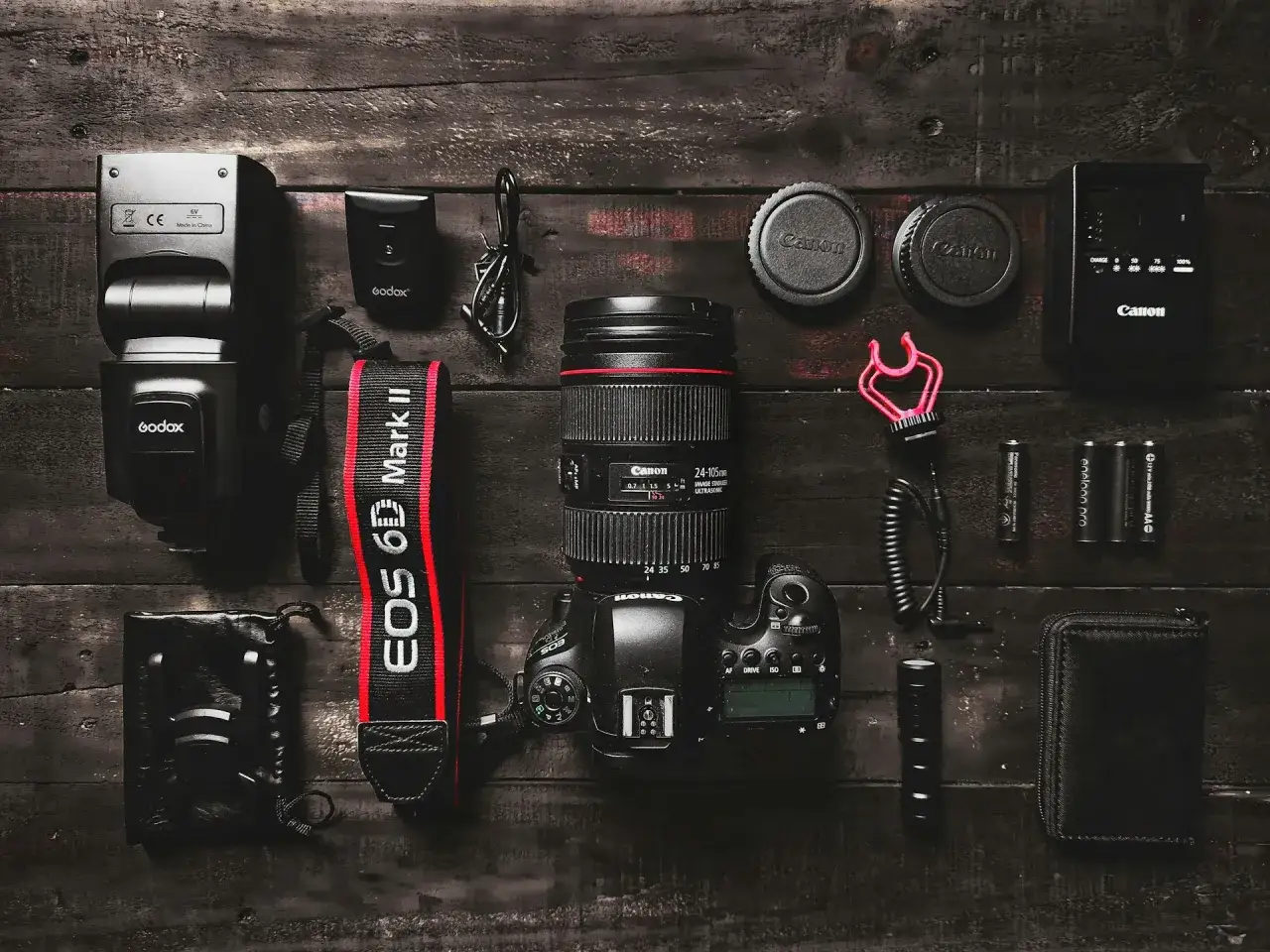 Zestaw fotograficzny: aparat Canon EOS 6D Mark II, obiektyw, lampa błyskowa Godox, baterie i akcesoria. Zastanawiasz się, ile kosztuje aparat?