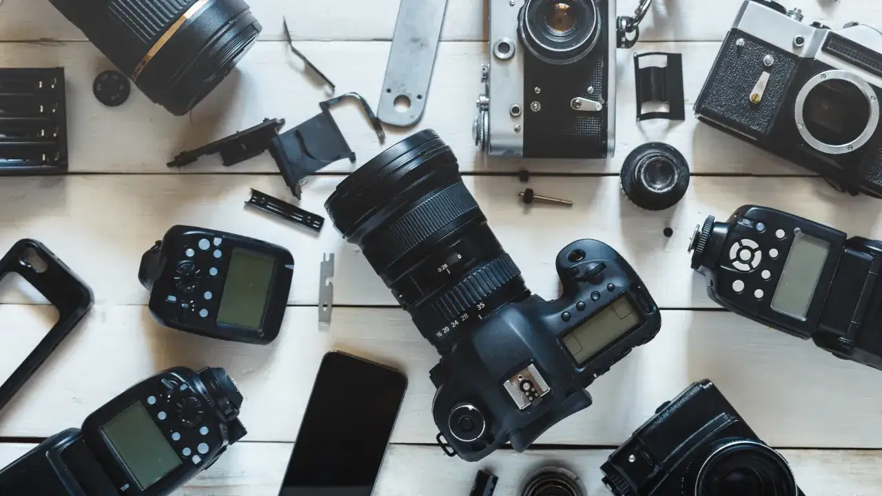 Zestaw sprzętu fotograficznego: lustrzanka, obiektywy, lampy błyskowe i akcesoria. Idealny do tworzenia rankingu aparatów.