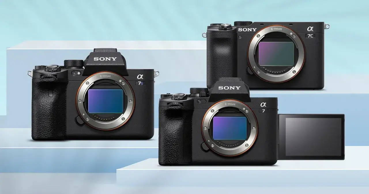 Trzy aparaty lustrzanki Sony Alpha z serii 7, w tym modele 7s, 7C i 7, prezentowane na białych stopniach.