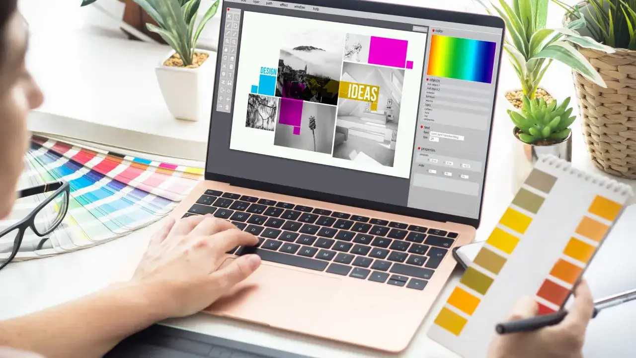 Grafik projektuje na laptopie, szukając inspiracji. Idealny laptop do Photoshop'a to taki, który ułatwia kreatywność.