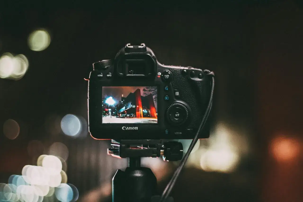 Canon na statywie, nocne miasto na ekranie. Zastanawiasz się, gdzie sprzedać aparat fotograficzny?