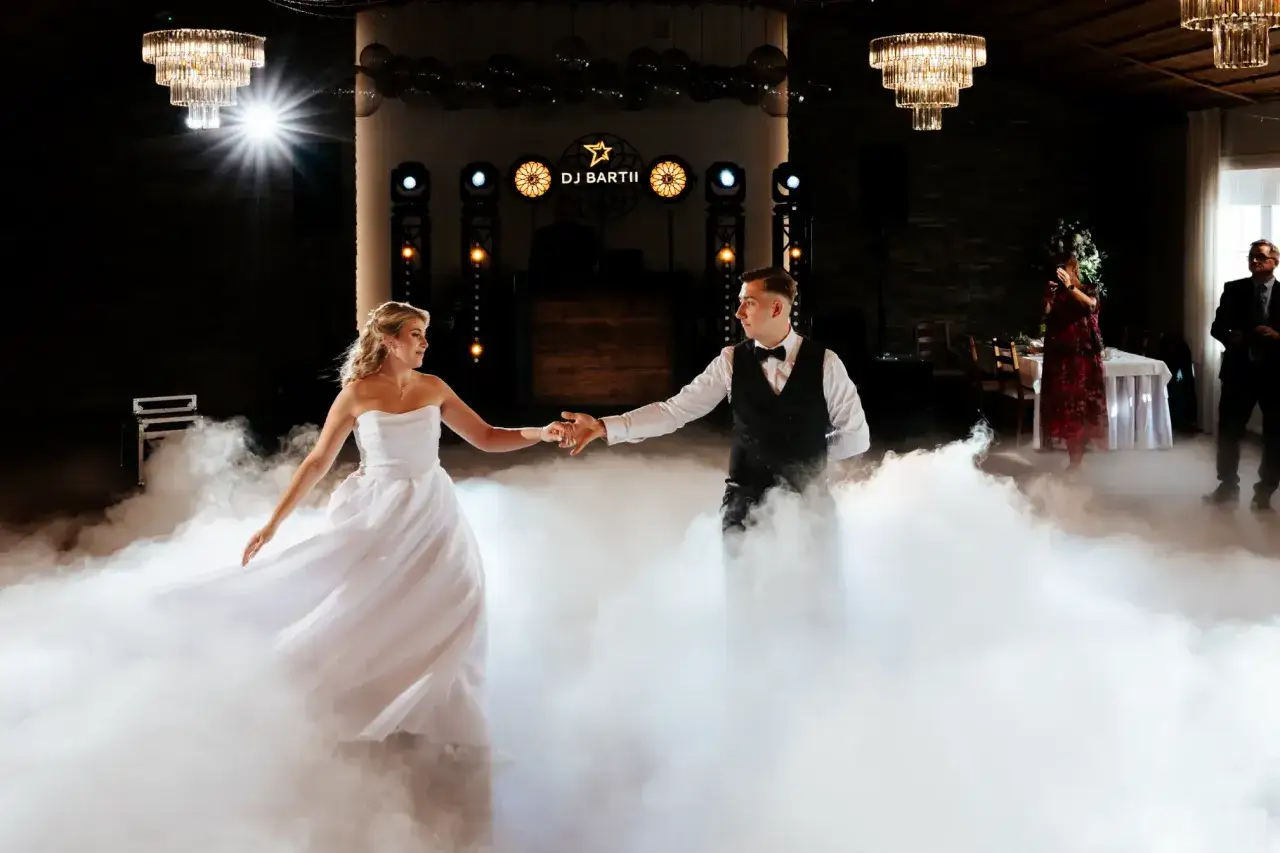 Para uwiecznić tak magiczny moment, jak pierwszy taniec, jakiego fotografa polecacie na wesele? Para młoda tańczy w chmurach dymu.