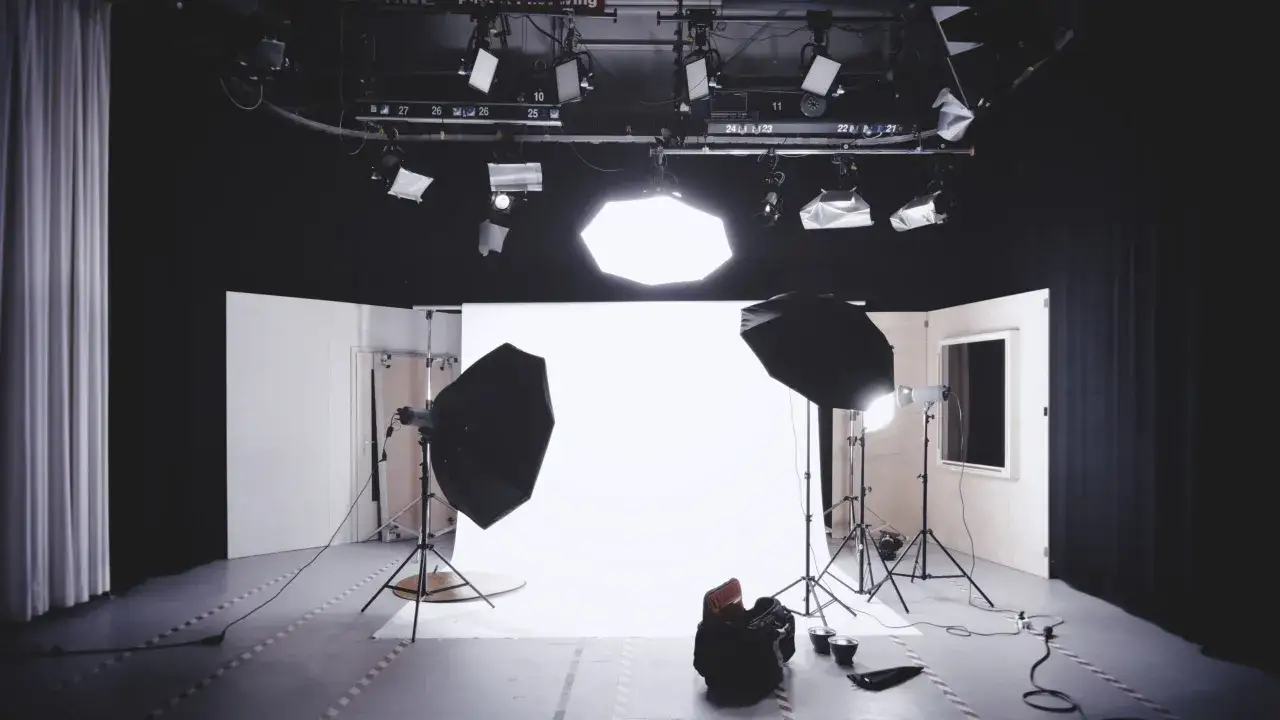 Studio do sesji zdjęciowej. Białe tło, lampy studyjne i softboxy – idealne warunki, jak zrobić zdjęcia na białym tle.